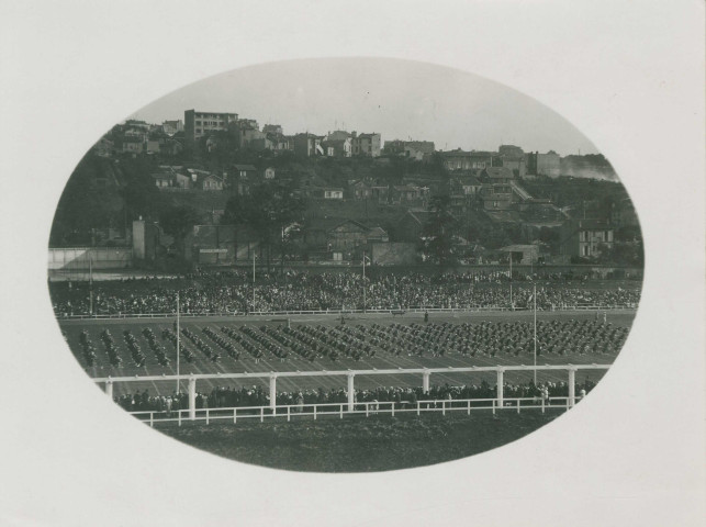 Fête d'éducation physique, vue large sur les mouvements d'ensemble, les spectateurs et les alentours au sud du stade : photographie noir et blanc.