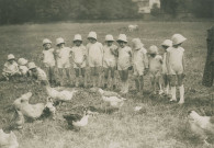 École de Plein-Air, enfants dans le jardin avec des animaux de basse-cour : photographie noir et blanc.