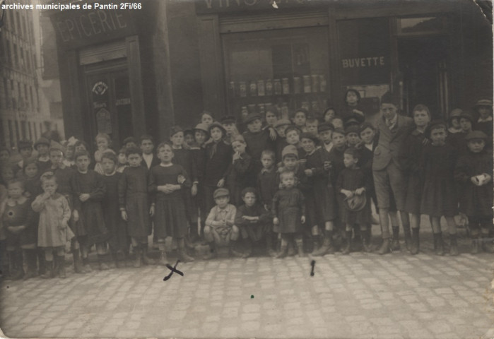 Groupe d'enfants devant une épicerie et café.
