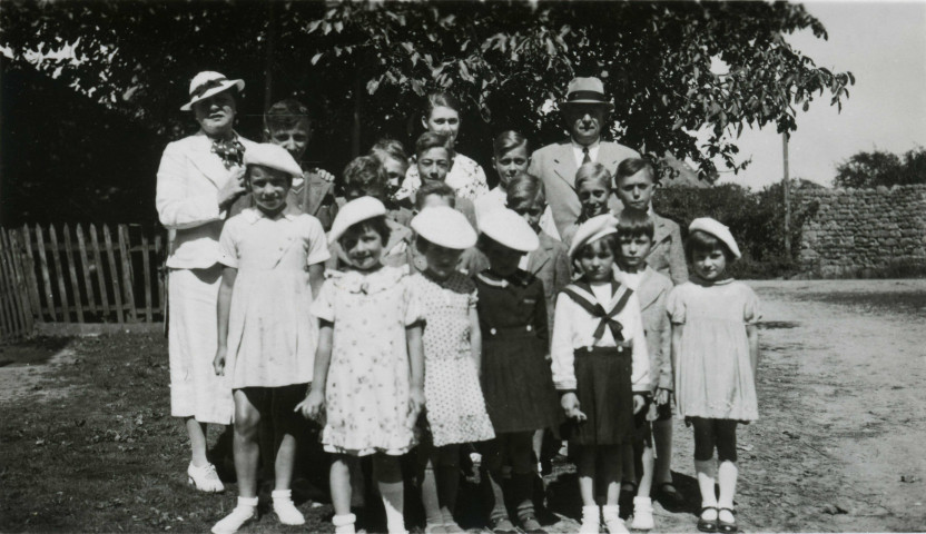 Colonies de vacances dans le nord du Morvan, groupe d'enfants posant avec le maire Charles Auray et son épouse à Chamont : photographie noir et blanc.