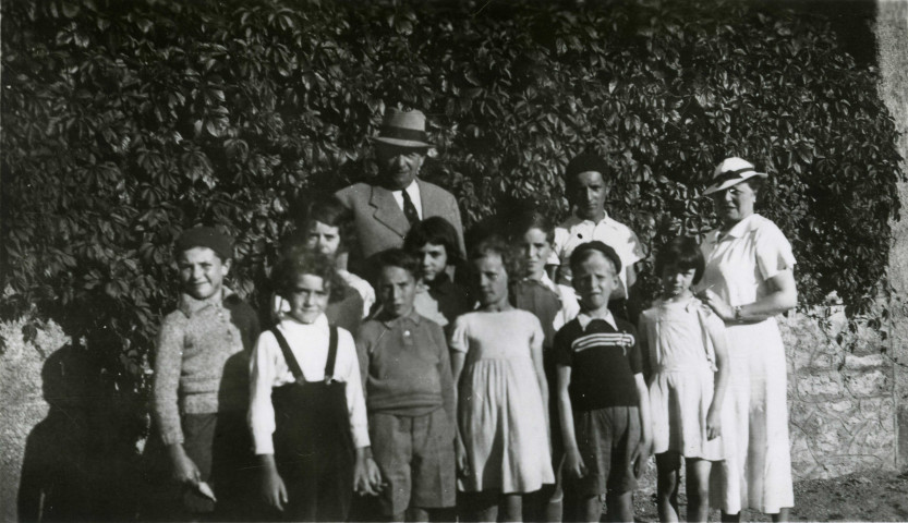 Colonies de vacances dans le nord du Morvan, groupe d'enfants posant avec le maire Charles Auray et son épouse à Sincey : photographie noir et blanc.