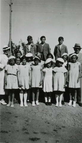 Colonies de vacances dans le nord du Morvan, groupe d'enfants posant avec le maire Charles Auray et son épouse à Romeneau : photographie noir et blanc.