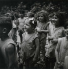 École de Plein-Air, groupe d'enfants chantant debout sur des chaises en extérieur : photographie noir et blanc.