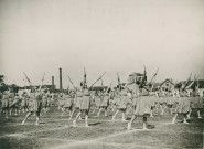 Fête d'éducation physique, mouvements d'ensemble avec des bâtons : photographie noir et blanc.