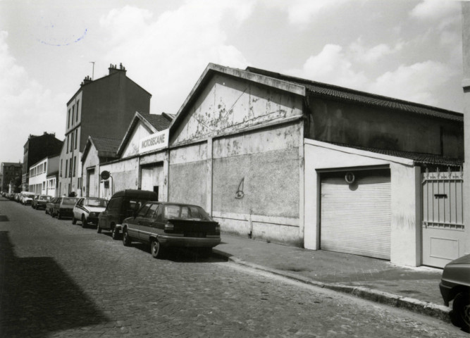 Usine Motobécane désaffectée, vue de la façade extérieure : photographie noir et blanc.