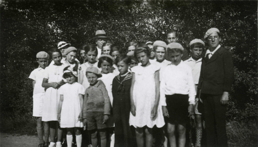 Colonies de vacances dans le nord du Morvan, groupe d'enfants posant avec le maire Charles Auray et son épouse à Joux (Saint-Andeux) : photographie noir et blanc.
