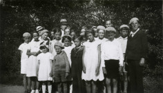 Colonies de vacances dans le nord du Morvan, groupe d'enfants posant avec le maire Charles Auray et son épouse à Joux (Saint-Andeux) : photographie noir et blanc.