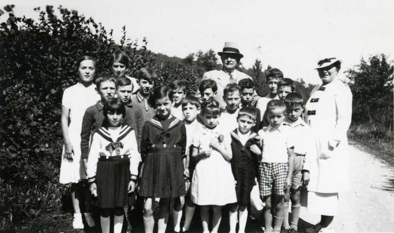 Colonies de vacances dans le nord du Morvan, groupe d'enfants posant avec le maire Charles Auray et son épouse au Bon Rupt : photographie noir et blanc.