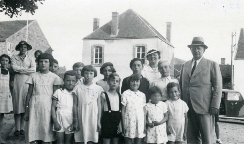 Colonies de vacances dans le nord du Morvan, groupe d'enfants posant avec le maire Charles Auray et son épouse au vieux château de Champmorlin : photographie noir et blanc.