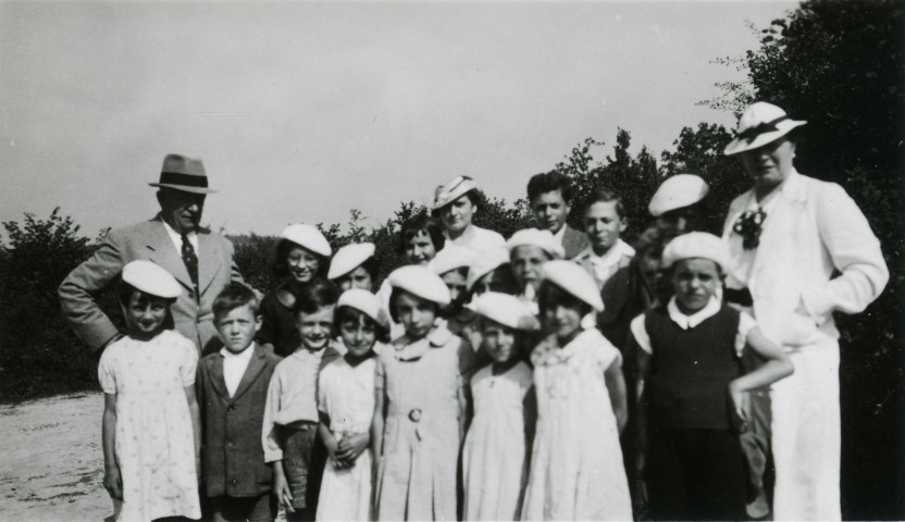 Colonies de vacances dans le nord du Morvan, groupe d'enfants posant avec le maire Charles Auray et son épouse à Chêne-Saint : photographie noir et blanc.