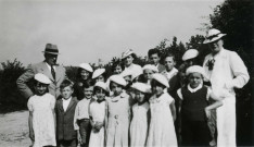 Colonies de vacances dans le nord du Morvan, groupe d'enfants posant avec le maire Charles Auray et son épouse à Chêne-Saint : photographie noir et blanc.