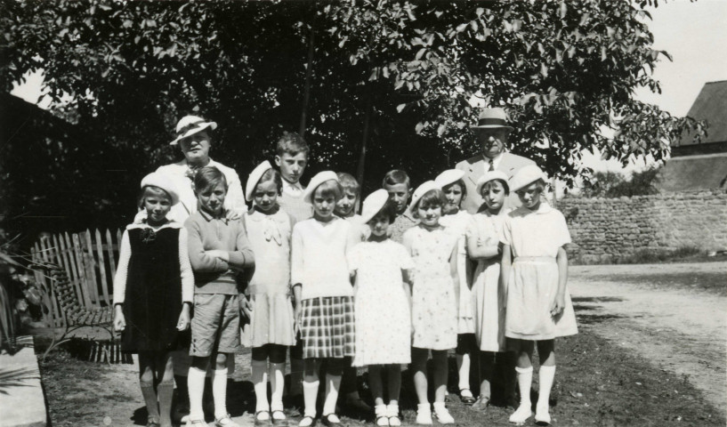 Colonies de vacances dans le nord du Morvan, groupe d'enfants posant avec le maire Charles Auray et son épouse à Chamont : photographie noir et blanc.