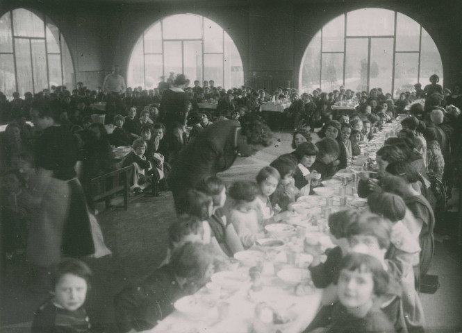 École de Plein-Air, repas en intérieur à l'occasion de la fête d'éducation physique : photographie noir et blanc.