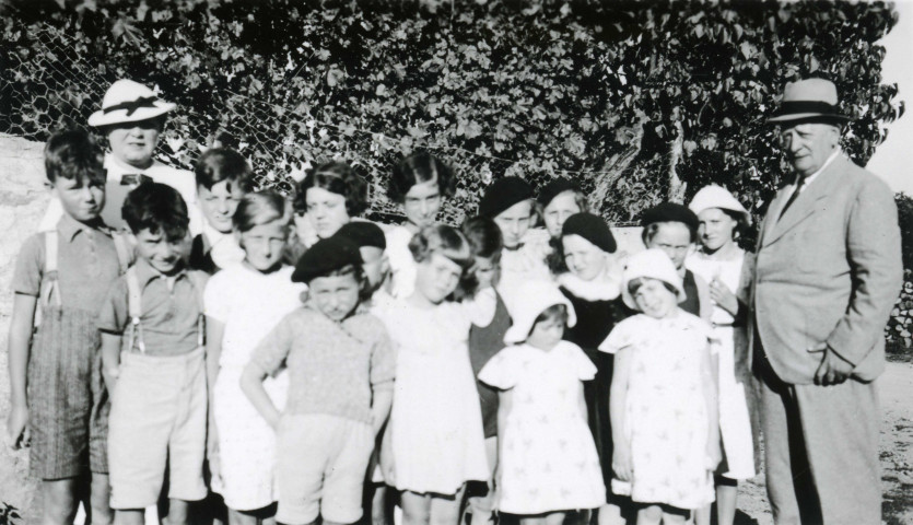 Colonies de vacances dans le nord du Morvan, groupe d'enfants posant avec le maire Charles Auray et son épouse à Molphey - Franceau - Cotâpre : photographie noir et blanc.
