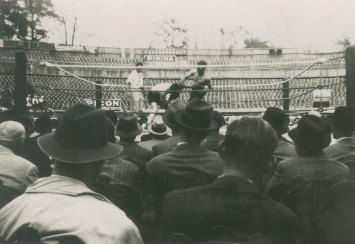 Combat de boxe sur un ring en extérieur : photographie noir et blanc.