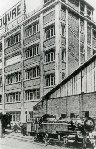 Magasins du Louvre, embranchement particulier ferroviaire au pied du bâtiment : reproduction d'une photographie noir et blanc.