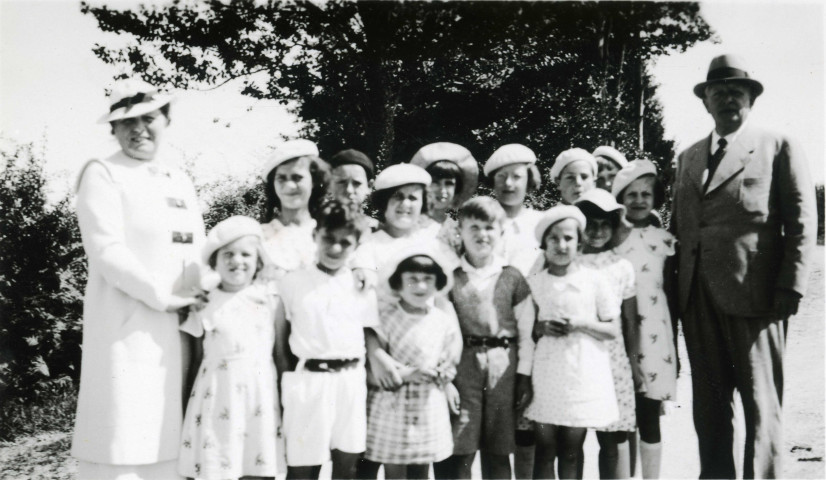 Colonies de vacances dans le nord du Morvan, groupe d'enfants posant avec le maire Charles Auray et son épouse à Les Blancs - Les Gras : photographie noir et blanc.
