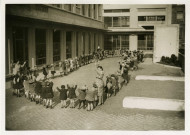 École maternelle de la route des Petits-Ponts, enfants faisant la ronde dans la cour : photographie noir et blanc.