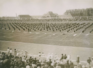 Fête d'éducation physique, vue large sur les mouvements d'ensemble, les spectateurs et les alentours au nord du stade : photographie noir et blanc.
