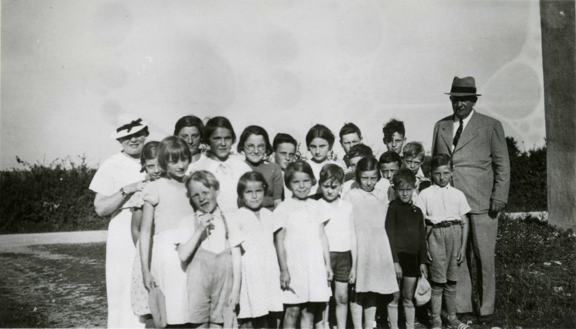Colonies de vacances dans le nord du Morvan, groupe d'enfants posant avec le maire Charles Auray et son épouse à Sully (Beauvilliers) : photographie noir et blanc.