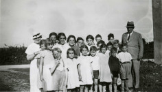Colonies de vacances dans le nord du Morvan, groupe d'enfants posant avec le maire Charles Auray et son épouse à Sully (Beauvilliers) : photographie noir et blanc.